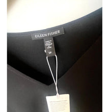 Load image into Gallery viewer, Eileen Fisher label on a black garment with a white background