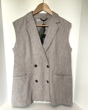 Load image into Gallery viewer, A sleeveless double-breasted blazer vest in a textured taupe-gray fabric, hanging on a wooden hanger against a white background.