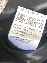 Load image into Gallery viewer, A close-up of a white garment care label sewn onto black fabric, showing laundry care symbols and Italian text including 'LAVAGGIO NON PERMESSO' and 'Made in Italy'.