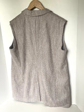 Load image into Gallery viewer, A sleeveless, high-neck vest in a heathered taupe-gray fabric, hanging on a wooden hanger against a plain white wall.