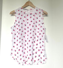 Load image into Gallery viewer, White sleeveless top with pink floral pattern on a hanger against a white wall.