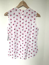 Load image into Gallery viewer, White sleeveless top with pink strawberry pattern on a wooden hanger against a white background