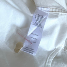 Load image into Gallery viewer, Close-up of a white shirt with a FRAME label and cotton content tag.