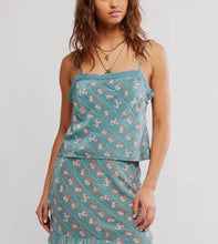 Load image into Gallery viewer, A woman wearing a two-piece camisole and skirt set in a dusty teal blue floral print, featuring a ruffled lace-trimmed camisole top and matching ruffled mini skirt.