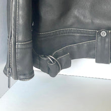 Load image into Gallery viewer, Close-up of a black leather jacket with zipper and button details on a light gray background