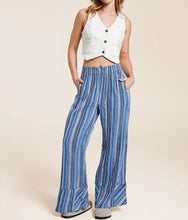 Load image into Gallery viewer, Woman wearing a white sleeveless top and blue striped pants on a beige background