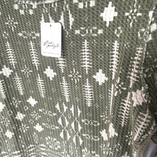 Load image into Gallery viewer, Textured fabric with a pattern and a visible brand tag.
