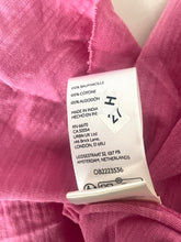 Load image into Gallery viewer, Close-up of a clothing label on pink fabric