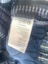 Load image into Gallery viewer, Clothing tag on a textured fabric background