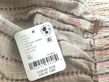 Load image into Gallery viewer, Close-up of a clothing tag on a textured fabric background