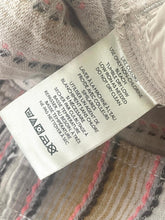 Load image into Gallery viewer, Close-up of a clothing label on a textured fabric background