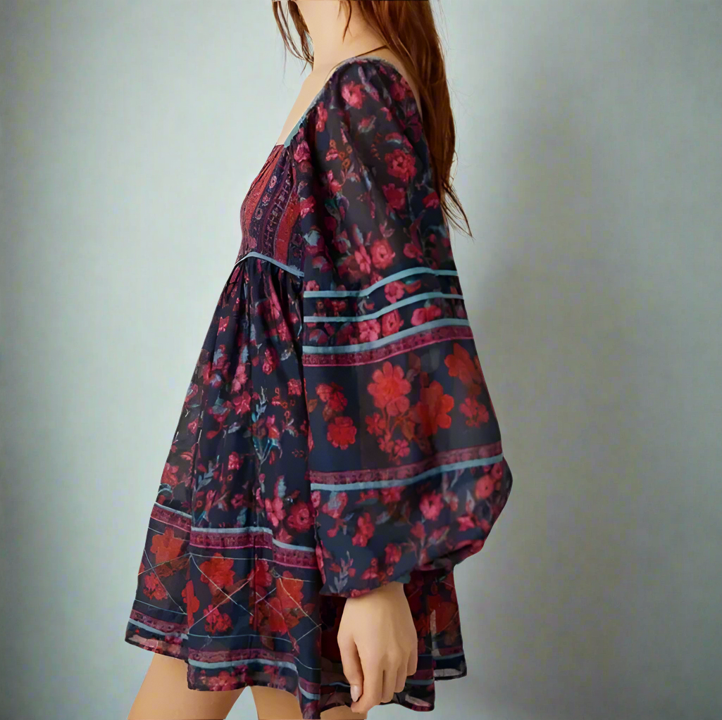 Woman wearing a floral dress with long sleeves against a plain background