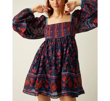 Load image into Gallery viewer, Woman wearing a floral dress with red and blue patterns on a plain background