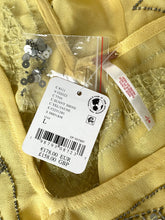 Load image into Gallery viewer, A close-up of a yellow fabric garment with a white product tag attached, showing the brand name 'Celine' and a barcode. The tag also includes a sewn-on size and color label reading 'C.
