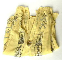 Load image into Gallery viewer, A pale yellow cotton bandana scarf with black geometric and dotted patterns, folded on a white background.