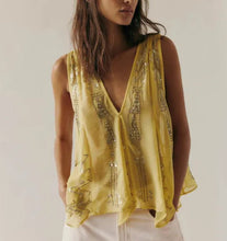 Load image into Gallery viewer, A woman wearing a sleeveless yellow top with metallic gold sequin embroidery and white pants, photographed against a plain light beige studio background.