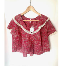 Load image into Gallery viewer, Red floral blouse with lace trim on a hanger against a white background