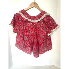 Load image into Gallery viewer, Red floral blouse with lace trim on a wooden hanger against a white background