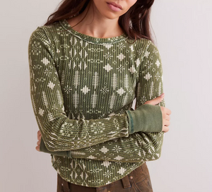 Person wearing a green patterned sweater against a plain background