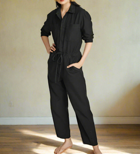 Person wearing a black jumpsuit on a white background