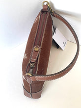 Load image into Gallery viewer, A brown leather shoulder bag with a textured finish, featuring a gold-tone snap button, zipper closure, and a white brand tag attached.