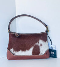 Load image into Gallery viewer, A Frye handbag made of brown and white cowhide with smooth brown leather trim, a top handle, and a black hangtag on a white background.