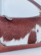 Load image into Gallery viewer, Brown and white cowhide shoulder bag with brown leather trim and a silver-tone metal snap closure.