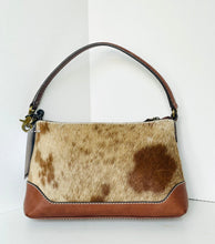 Load image into Gallery viewer, A small handbag with a brown and beige cowhide patterned body, brown leather trim, and a single brown shoulder strap, photographed against a plain white background.