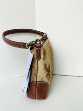 Load image into Gallery viewer, A small handbag with a brown leather handle and trim, combined with a tan and brown cowhide body, shown with a white product tag against a white background.