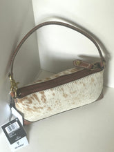 Load image into Gallery viewer, A small shoulder bag with a brown and cream cowhide pattern body, brown leather trim, and a single shoulder strap, shown with a product tag attached against a plain light background.