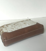 Load image into Gallery viewer, A rectangular zippered pouch featuring a brown leather base and a white cowhide-patterned top panel, shown on a plain light gray background.
