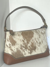 Load image into Gallery viewer, A shoulder handbag with a brown and white cowhide patterned body, brown leather trim, and a brown shoulder strap, shown against a plain light background.