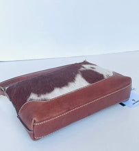 Load image into Gallery viewer, A brown leather and cowhide shoulder bag with a brown and white cowhide top panel and brown leather sides, shown on a plain white background.