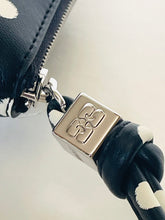 Load image into Gallery viewer, Close-up of a black leather product with a silver zipper pull featuring a logo.