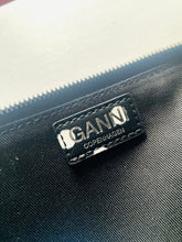 Load image into Gallery viewer, Close-up of a brand label on a textured surface