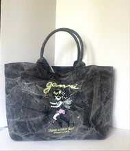 Load image into Gallery viewer, A black marbled tote bag with dual top handles, featuring a graphic of a fairy and the text 'ganni Have a nice day!'.