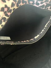 Load image into Gallery viewer, Close-up of a black pouch with leopard print lining and visible brand logo.