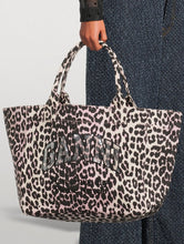 Load image into Gallery viewer, Leopard print tote bag with 'Ganni' branding held by a person against a neutral background