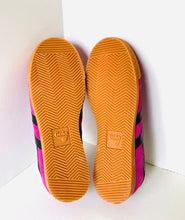 Load image into Gallery viewer, A pair of Adidas Babylone sneakers shown from the sole view, featuring a bright orange treaded rubber sole and magenta pink and black side stripes.