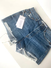 Load image into Gallery viewer, Blue denim shorts with a tag on a white surface