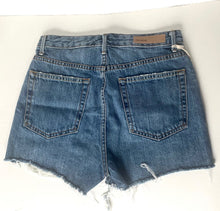 Load image into Gallery viewer, Folded blue jeans on a white surface