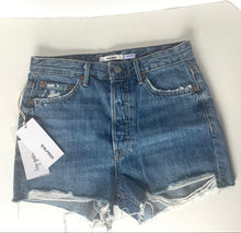 Load image into Gallery viewer, Folded denim shorts with a tag on a white background