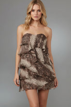 Load image into Gallery viewer, Woman wearing a strapless, ruffled dress with a textured pattern on a gray background