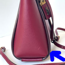 Load image into Gallery viewer, Close-up of a maroon handbag with gold accents on a white background