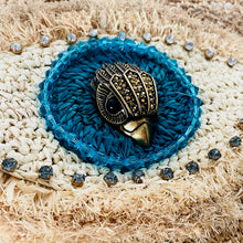 Load image into Gallery viewer, Blue woven coaster with a decorative metal beetle on a textured surface