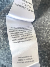 Load image into Gallery viewer, Close-up of a tie label with text on a textured surface