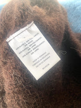 Load image into Gallery viewer, Close-up of a label on a brown fabric with text