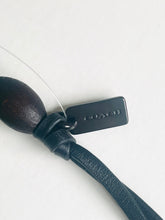 Load image into Gallery viewer, Dark blue leather strap with wooden spoon and tag on a white background