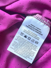 Load image into Gallery viewer, Fabric tag on a pink textured fabric background