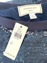 Load image into Gallery viewer, Close-up of a Moulinette Soeurs garment neck label and hanging price tag over a dark blue sequined fabric.